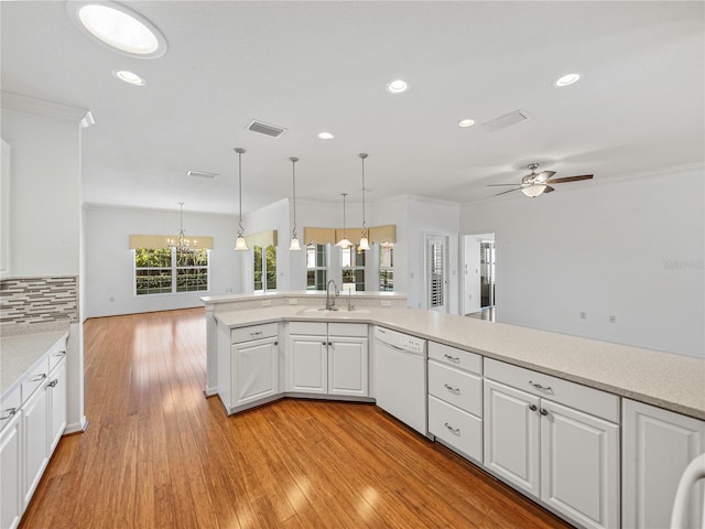 kitchen featuring light wood-type flooring, ceiling fan with notable chandelier, white dishwasher, sink, and white cabinetry