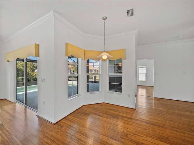 unfurnished dining area featuring wood-type flooring and ornamental molding