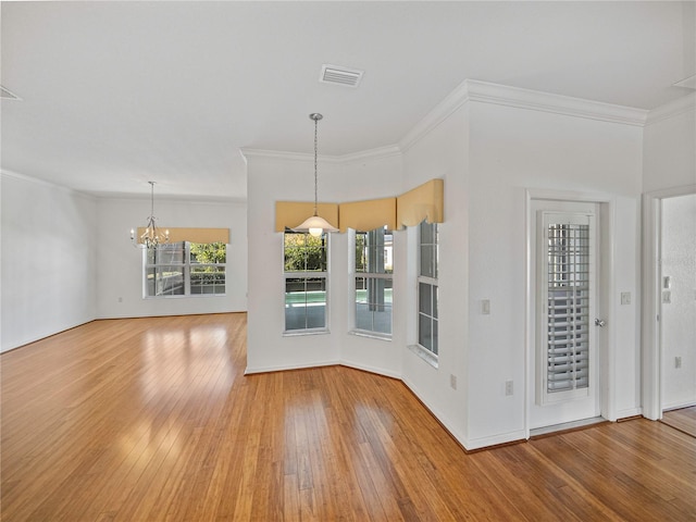 interior space featuring hardwood / wood-style floors, crown molding, and a notable chandelier