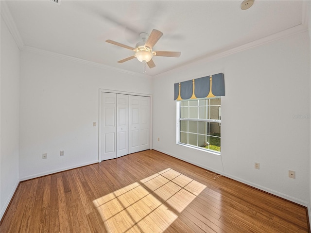 unfurnished bedroom featuring a closet, ceiling fan, hardwood / wood-style floors, and ornamental molding