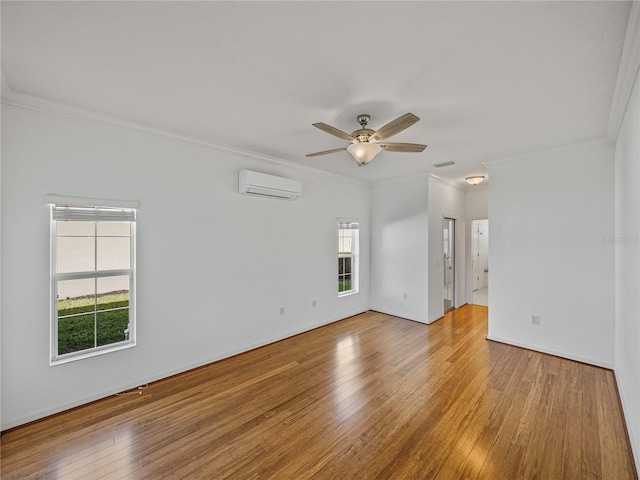 empty room featuring plenty of natural light, wood-type flooring, and ornamental molding