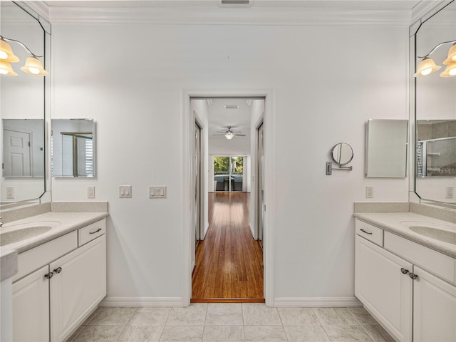 bathroom with ceiling fan, vanity, ornamental molding, and hardwood / wood-style flooring