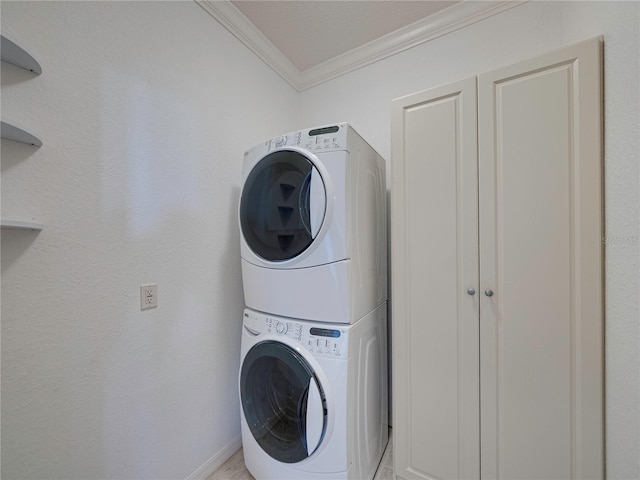 washroom featuring stacked washing maching and dryer and ornamental molding