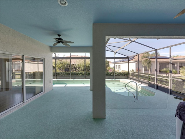 view of pool with glass enclosure and ceiling fan