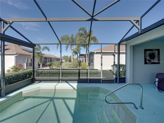 view of swimming pool featuring glass enclosure