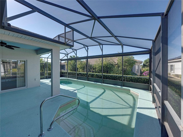 view of pool with a patio, glass enclosure, and ceiling fan