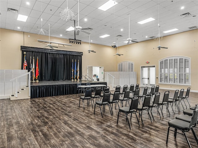 misc room featuring a paneled ceiling, ceiling fan, a towering ceiling, and hardwood / wood-style flooring