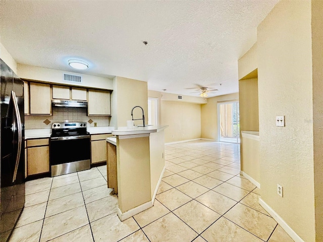 kitchen featuring black refrigerator, backsplash, ceiling fan, light tile patterned floors, and stainless steel electric range