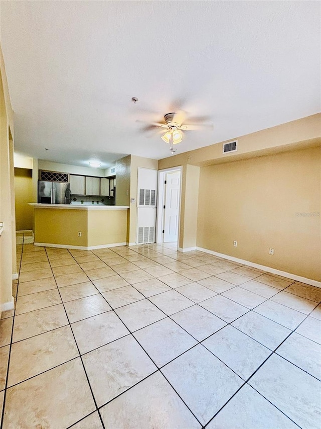 unfurnished living room with light tile patterned floors, a textured ceiling, and ceiling fan