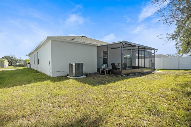 back of house featuring a sunroom, central AC unit, and a yard