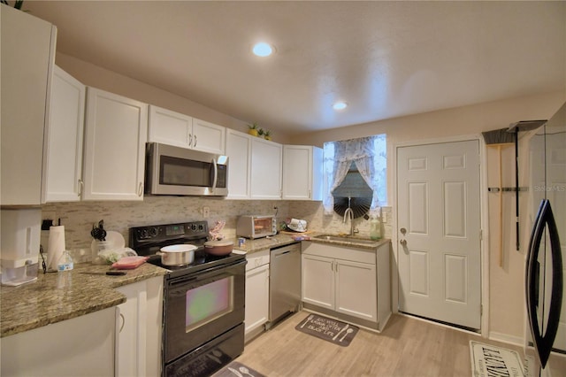 kitchen with white cabinetry, sink, stainless steel appliances, and light wood-type flooring