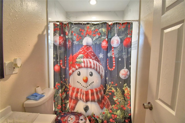 bathroom with a shower with curtain and toilet