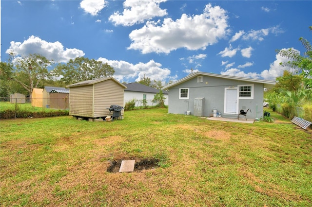 rear view of property with a yard and a storage shed