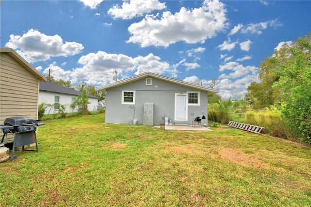 back of property featuring a lawn and a patio area