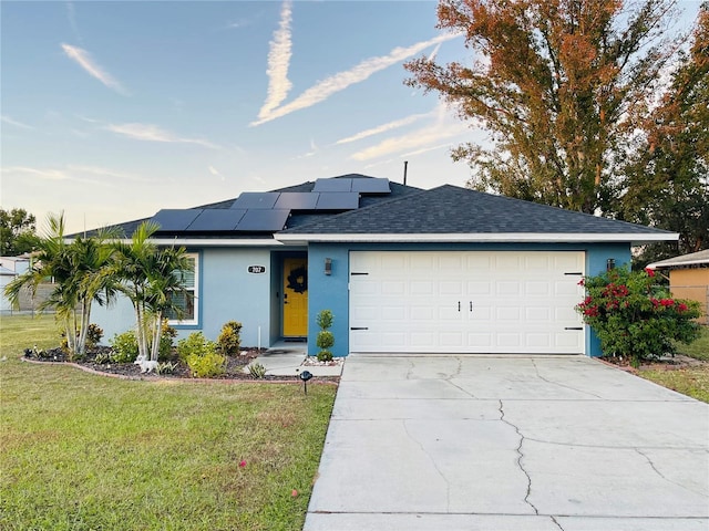 ranch-style home with a garage, a front yard, and solar panels