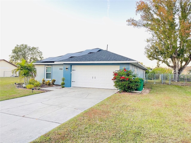 view of front of home featuring a front lawn, a garage, and solar panels