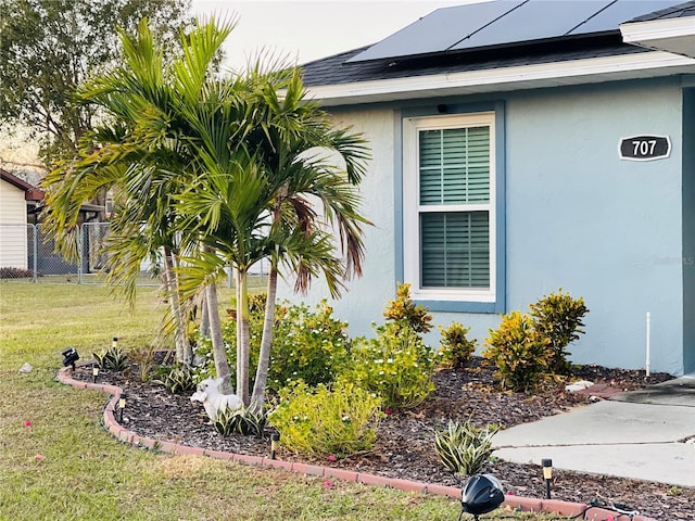 view of home's exterior featuring solar panels and a lawn