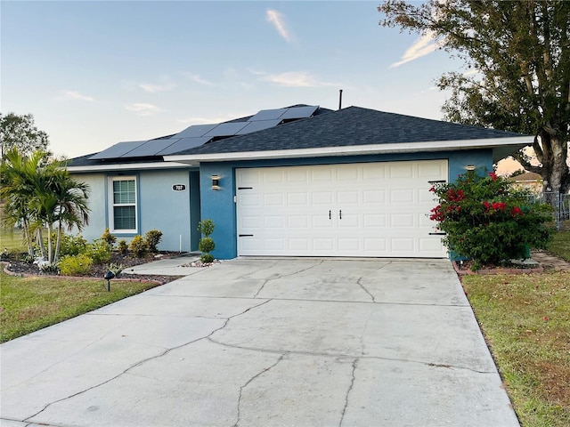 ranch-style house with solar panels and a garage