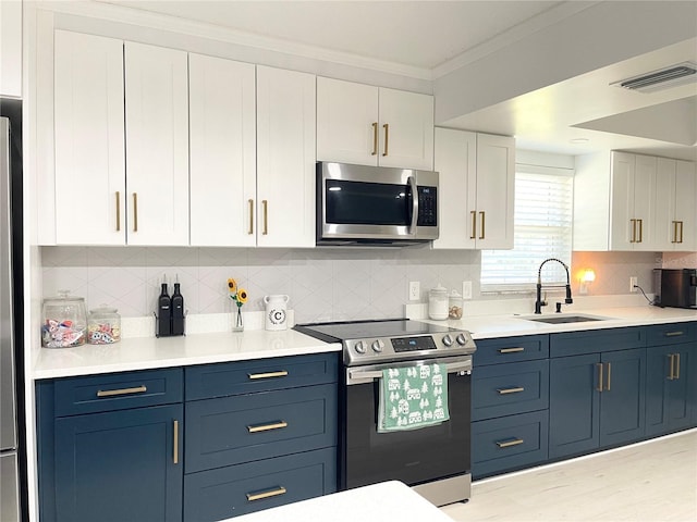 kitchen with white cabinetry, sink, stainless steel appliances, blue cabinets, and crown molding