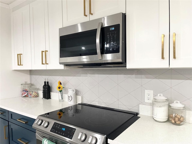 kitchen with decorative backsplash, white cabinetry, stainless steel appliances, and blue cabinets