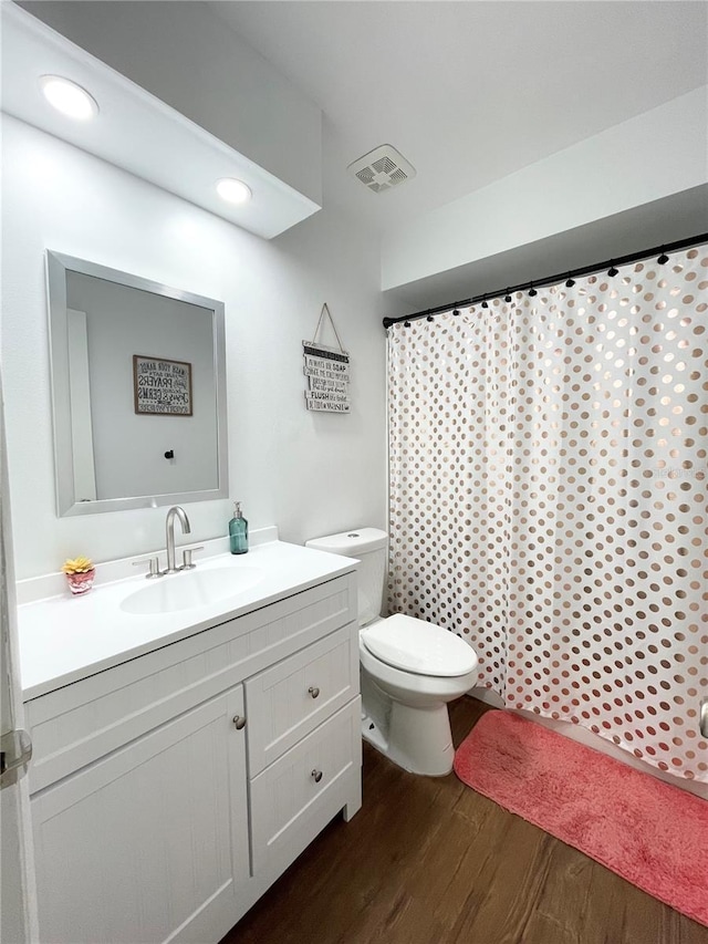 bathroom with hardwood / wood-style floors, vanity, and toilet