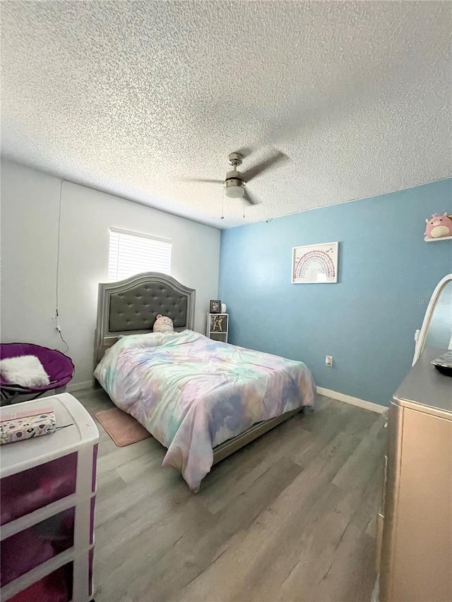 bedroom featuring hardwood / wood-style floors, a textured ceiling, and ceiling fan