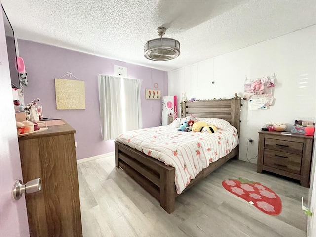 bedroom featuring a textured ceiling and light wood-type flooring