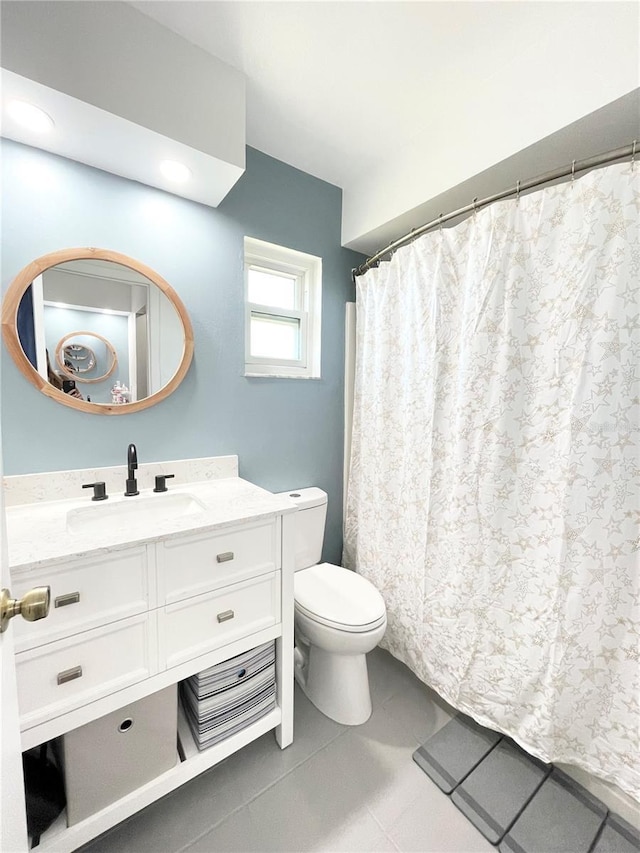 bathroom with tile patterned flooring, vanity, and toilet