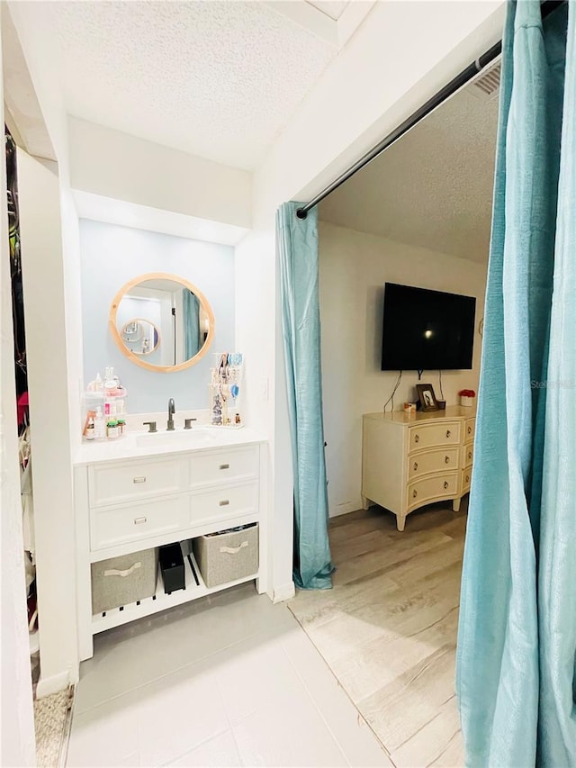 bathroom with vanity, wood-type flooring, and a textured ceiling