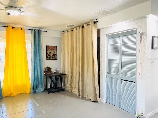 interior space with ceiling fan and a closet