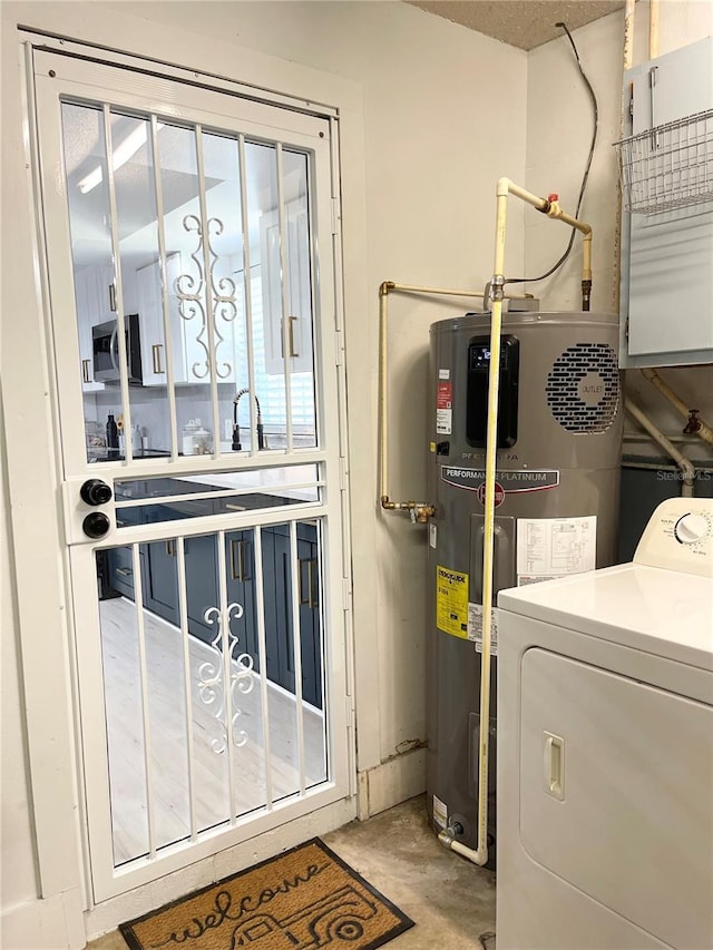 clothes washing area with washer / dryer, sink, and heat pump water heater