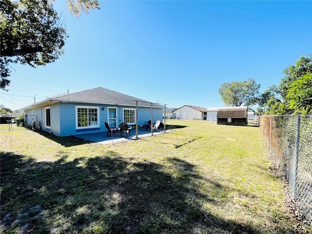 rear view of house with a patio, a storage unit, and a lawn