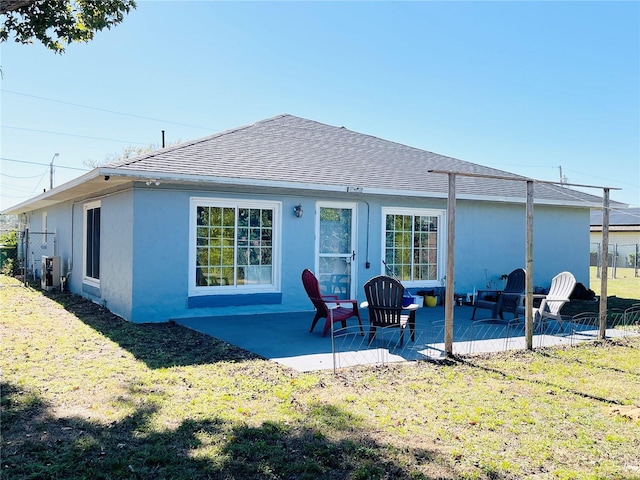 rear view of property featuring a lawn and a patio area