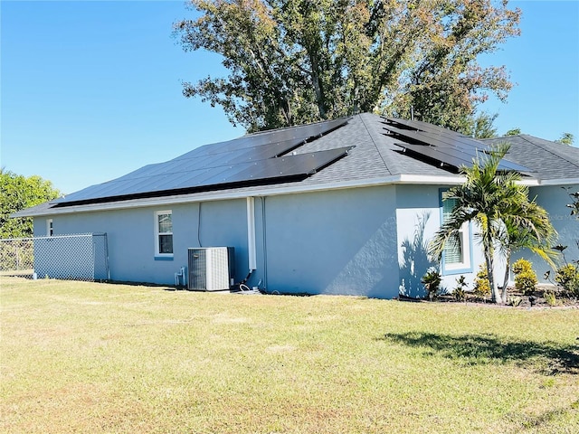 view of side of home featuring a yard and central AC unit