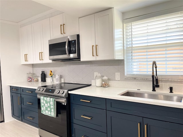 kitchen with tasteful backsplash, sink, white cabinets, and stainless steel appliances