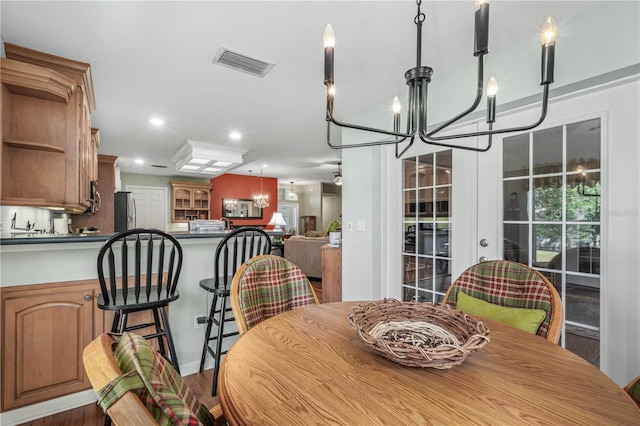 dining room with hardwood / wood-style floors and an inviting chandelier