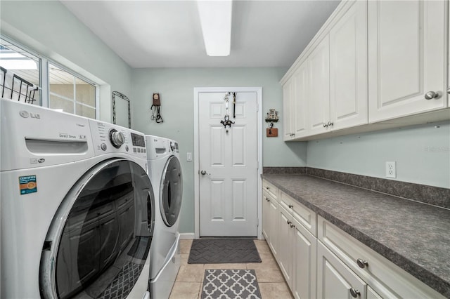 laundry area with washer and clothes dryer, cabinets, and light tile patterned floors