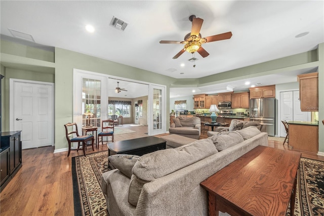 living room featuring ceiling fan, french doors, and light wood-type flooring