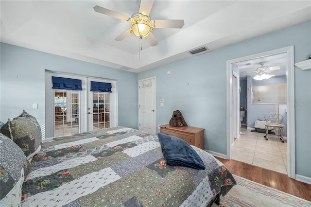 bedroom featuring ceiling fan, light hardwood / wood-style floors, and french doors