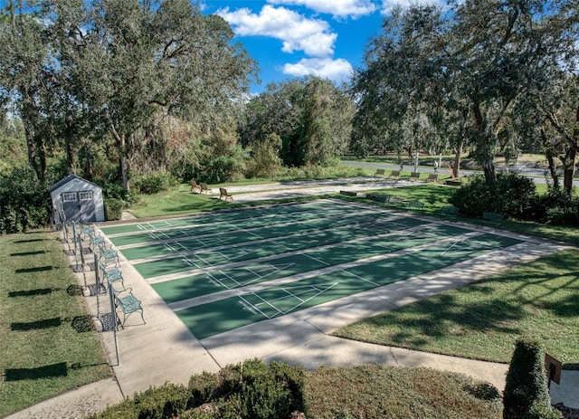 view of community featuring a yard and a storage shed