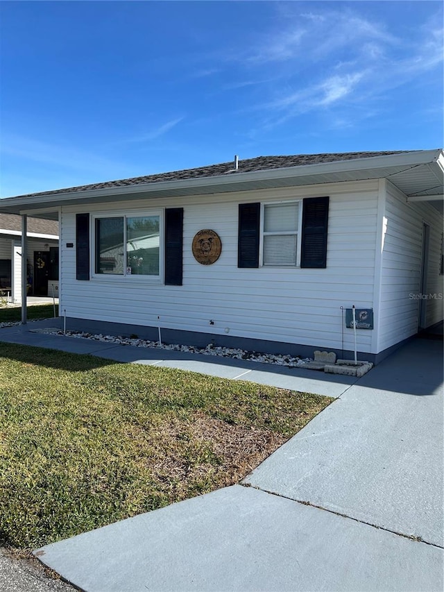 view of front of house with a front lawn and a carport