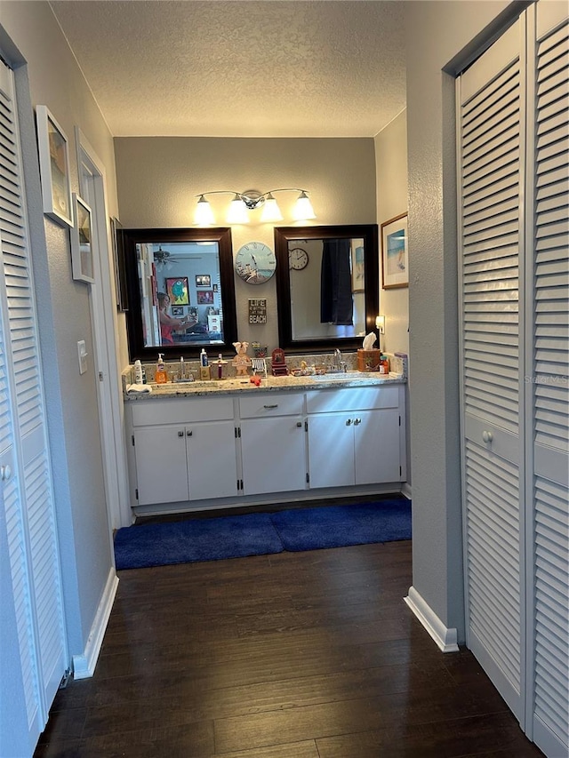 bathroom with hardwood / wood-style floors, vanity, and a textured ceiling