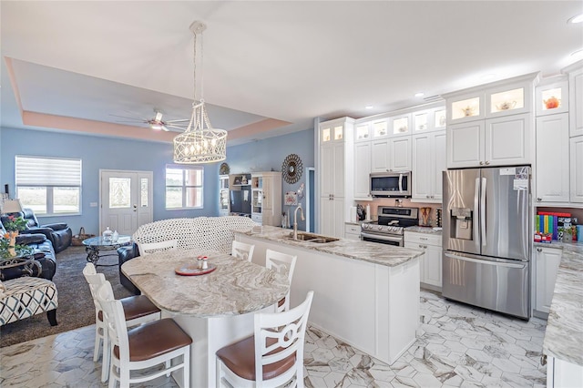 kitchen with white cabinetry, a center island with sink, pendant lighting, and appliances with stainless steel finishes