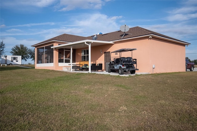 rear view of house with a sunroom and a lawn