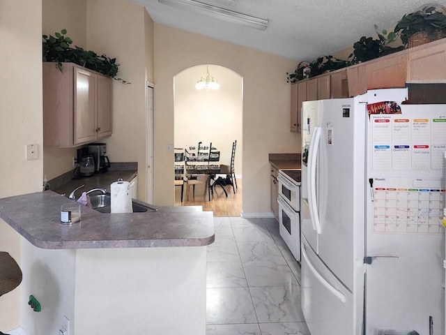 kitchen with kitchen peninsula, a textured ceiling, white appliances, sink, and a notable chandelier