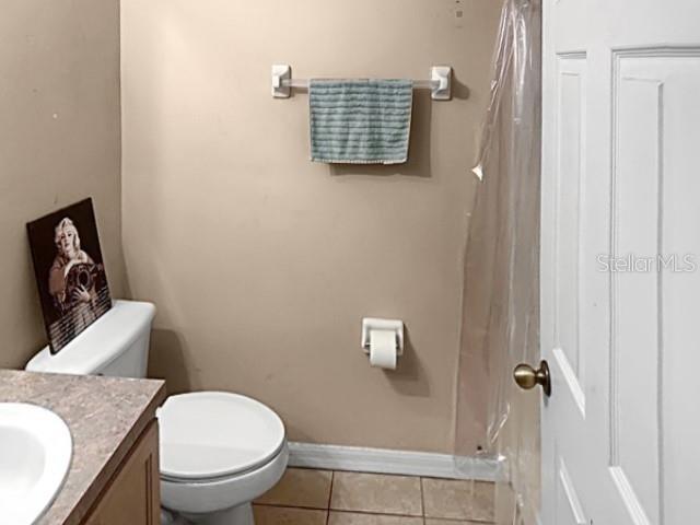 bathroom featuring tile patterned flooring, vanity, and toilet