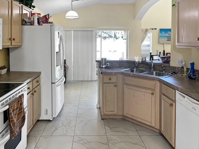 kitchen with pendant lighting, light brown cabinets, white appliances, and sink