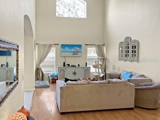 living room featuring a high ceiling and light wood-type flooring