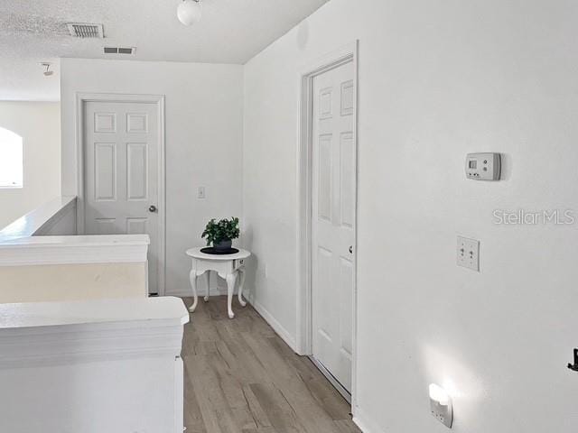 interior space with light hardwood / wood-style flooring and a textured ceiling