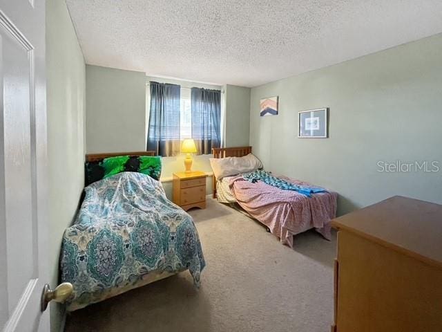 bedroom featuring carpet flooring and a textured ceiling